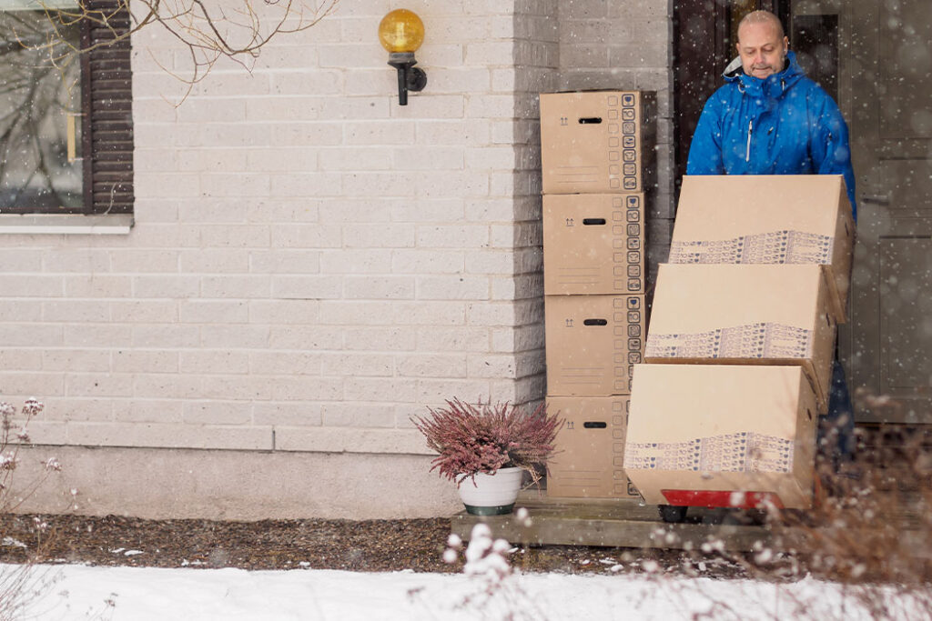 A Man Carries Moving Boxes In January